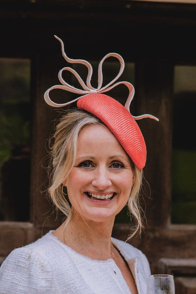 Woman wearing a decorative pink headpiece with a blurred background